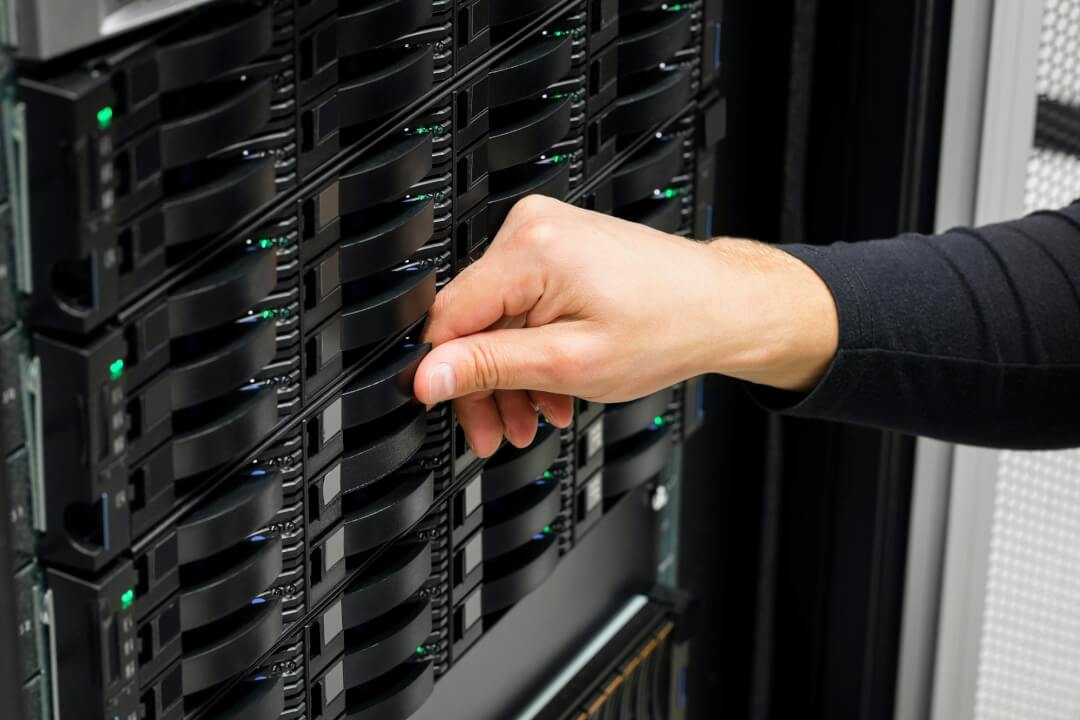 IT Engineer's Hand Replacing Hard Drive In Data Center